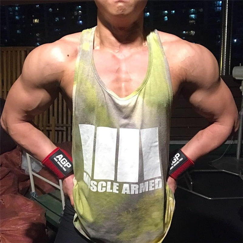 Person wearing a 'Muscle Armed' tank top with visible branding, standing indoors.